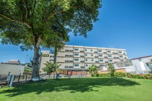 a large building with a tree in a park at Jasmine Resort Hotel and Serviced Apartment in Si Racha