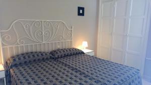 a bedroom with a bed with a blue and white comforter at Apartamentos ORLANDO en Costa Adeje in Adeje