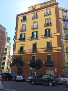 ナポリにあるGaribaldi House Apartmentの車が目の前に停まった高い黄色の建物