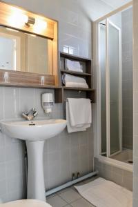 W łazience znajduje się umywalka i lustro. w obiekcie Hôtel Le Relais Dax w mieście Dax