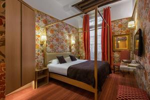 a bedroom with a bed in a room with floral wallpaper at Hôtel Saint-Paul Rive-Gauche in Paris