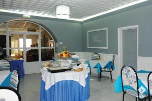 ein Esszimmer mit einem Tisch und blauen Stühlen in der Unterkunft Dona Maria in Portalegre