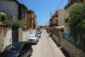 a row of cars parked on a narrow street at B&B Villa Adriana in San Leone