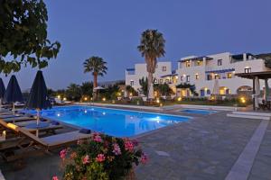 a view of a swimming pool with chairs and a building at Fragoulis Village in Parasporos