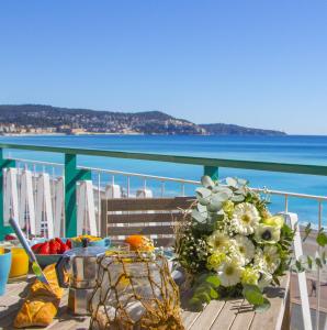 ニースにあるMY CASA - 131 PROMENADE DES ANGLAISのバルコニーに花束付きのテーブル