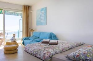 a bedroom with a bed and a blue couch at MY CASA - 131 PROMENADE DES ANGLAIS in Nice