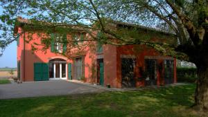 a red building with a tree in front of it at B&B L'Alberone in Budrio
