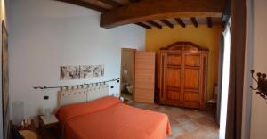 a bedroom with an orange bed and a wooden door at B&B L'Alberone in Budrio