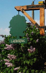 ブドリオにあるB&B L'Alberoneの花の前にリグネブールを読む緑色の看板