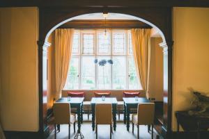 a dining room with a table and chairs and a window at The Coed-Y-Mwstwr Hotel in Bridgend