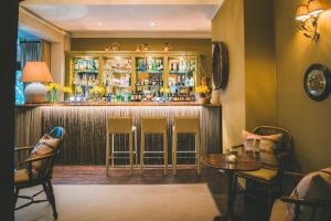 a bar in a room with chairs and a table at The Coed-Y-Mwstwr Hotel in Bridgend +17 photos