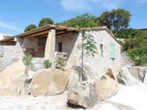 a stone house on a hill with rocks at Résidence Les Pavillons du Belvédère in Porto-Vecchio