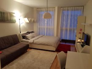 una pequeña sala de estar con cama y sofá en Rotermanni Guest Apartments, en Tallin