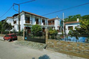 a house with a red car parked in front of it at Charoula in Platanias