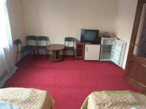 Habitación con mesa, sillas y TV. en Tis Hotel, en Krasnodar