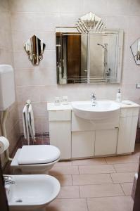La salle de bains est pourvue d'un lavabo, de toilettes et d'un miroir. dans l'établissement Casa Maddy, à Bardolino