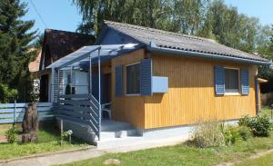 ドムボーバールにあるFerienhaus Gunarasの青いシャッターとポーチのある小さな家