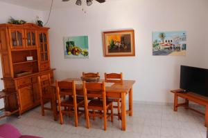 a dining room with a wooden table and chairs at Apartamentos Gabriel Sans in Fornells