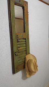 un espejo con un sombrero colgado en la pared en Suíte Cravo & Canela, en São Pedro da Serra
