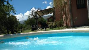 a swimming pool in front of a house at Cabañas Chacras del Arroyo Vidal in Carpintería