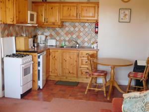 a kitchen with a table and a white refrigerator at O'Briens Apartments in Ballylongford