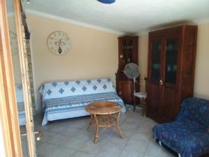 a bedroom with a bed and a table and a clock at la Piazzetta in Santa Caterina