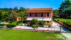 una casa con una recinzione di fronte a un cortile di Gregory-Vassilis Apartments a Dassia