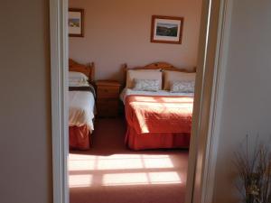 a bedroom with two twin beds and a doorway at O'Briens Apartments in Ballylongford