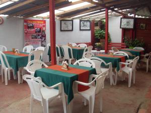 un grupo de mesas y sillas con manteles verdes y rojos en Finca Hotel Nutabes, en San Pedro