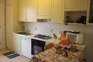 a kitchen with white cabinets and a table with a microwave at Appartamento Galileo in Padova