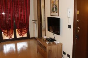 Appartamento Galileo في بادوفا: غرفة معيشة مع تلفزيون وطاولة خشبية