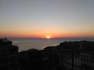een zonsondergang over de oceaan met de zon in de horizon bij Hotel Filland in Sozopol