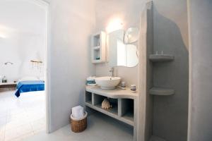 uma casa de banho com um lavatório e um espelho em Venia's Guesthouse em Pollonia