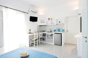 a white kitchen with a sink and a desk at Venia's Guesthouse in Pollonia