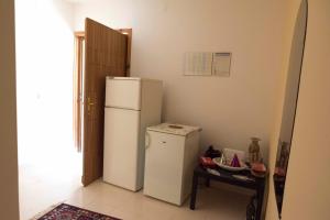 a kitchen with a white refrigerator and a table at Guest House Alek in Vrboska