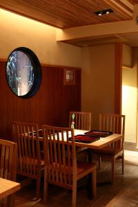 een eetkamer met een tafel en houten stoelen bij Yasaka Yutone Kyokoyado in Kyoto