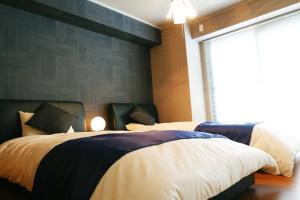 a bedroom with two beds and a large window at Chidori Inn Fukuromachi Hiroshima in Hiroshima