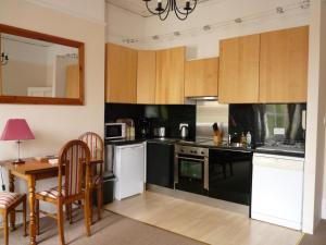 una cocina con electrodomésticos en blanco y negro y una mesa en Paragon Serviced Apartments, en Cheltenham