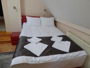Sport Hotel في فيسبرم: سرير عليه وسائد بيضاء في الغرفة
