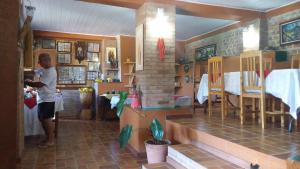 a woman standing in a room with a kitchen at Pousada Pinhalense in Santo Antônio do Pinhal