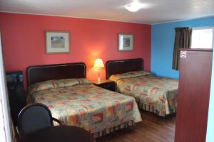 2 Betten in einem Zimmer mit roten und blauen Wänden in der Unterkunft Colonial Motel in Chatham