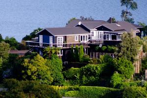 a house on top of a hill with trees at Ngamihi Lodge in Rotorua