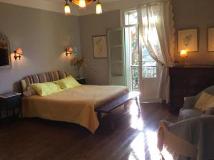 a bedroom with a bed and a couch and a window at Villa Delphina in Vernet-les-Bains