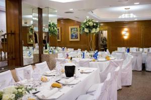 una sala de banquetes con mesas blancas y sillas blancas en Hotel Marivella, en Calatayud