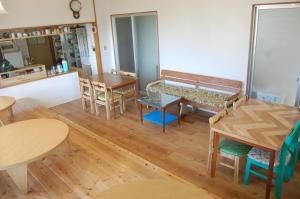 a room with wooden tables and chairs and a counter at Minshuku Namisou in Iriomote