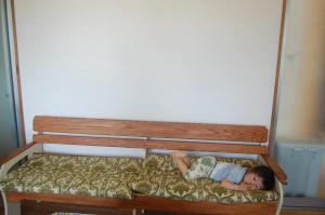 a small child laying on the bottom bunk of a bed at Minshuku Namisou in Iriomote