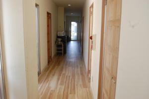an empty hallway with a wooden floor in a house at Minshuku Namisou in Iriomote