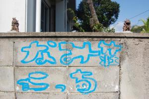 a cement wall with blue writing on it at Minshuku Namisou in Iriomote