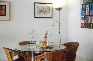 a glass table with wicker chairs and a lamp at GRAYHAUS Guest House in Petaling Jaya