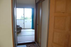 einen Flur mit Spiegel und eine Tür mit Tür in der Unterkunft Minshuku Namisou in Iriomote